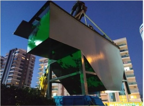 Industrial sludge treatment unit being installed by crane